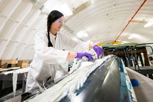 NREL researcher Robynne Murray works on a thermoplastic composite turbine blade at the Composites Manufacturing Education and Technology Facility at NREL's Flatirons Campus. Photo by Dennis Schroeder NREL manufacturing wind turbine blades recyclability